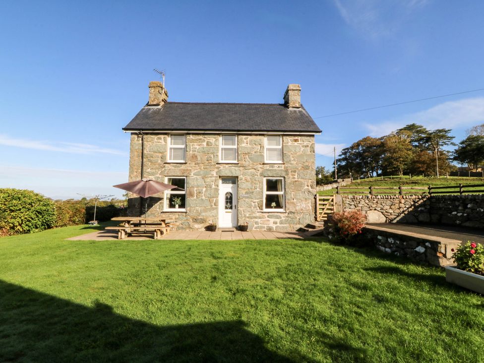 A stone house with a garden and picnic table at Tyddyn in Dyffryn Ardudwy