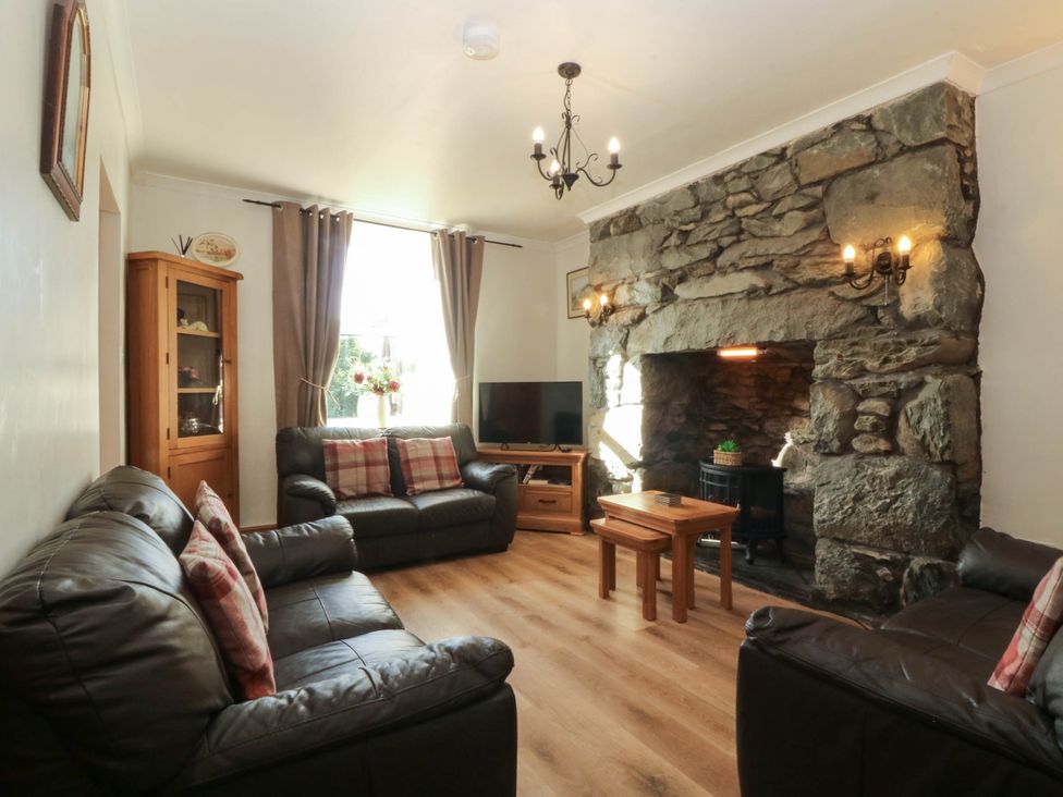 A living room with sofas and a fireplace at Tyddyn in Dyffryn Ardudwy