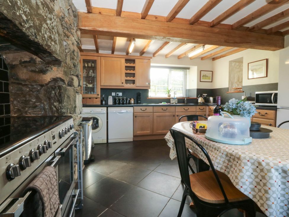 A kitchen with wooden cabinets and appliances at Tyddyn Dyffryn Ardudwy