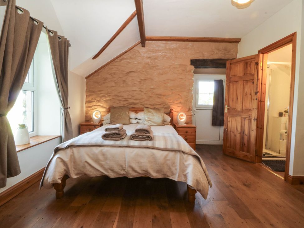 A bedroom with a bed and nightstand at Tyddyn in Dyffryn Ardudwy
