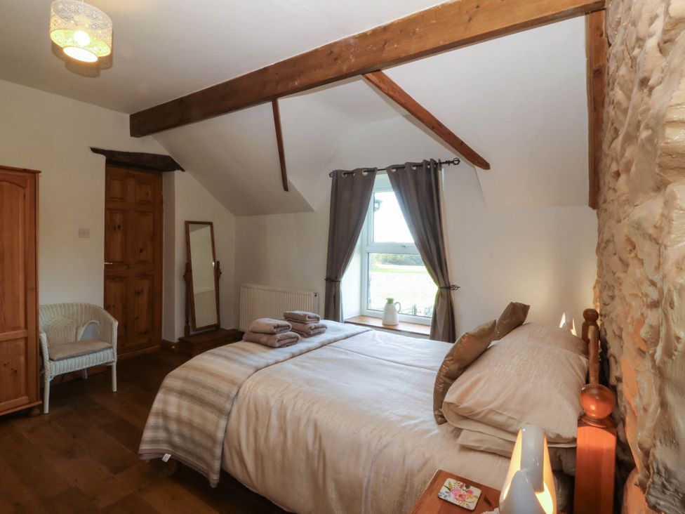 A bedroom with a bed and wardrobe at Tyddyn in Dyffryn Ardudwy