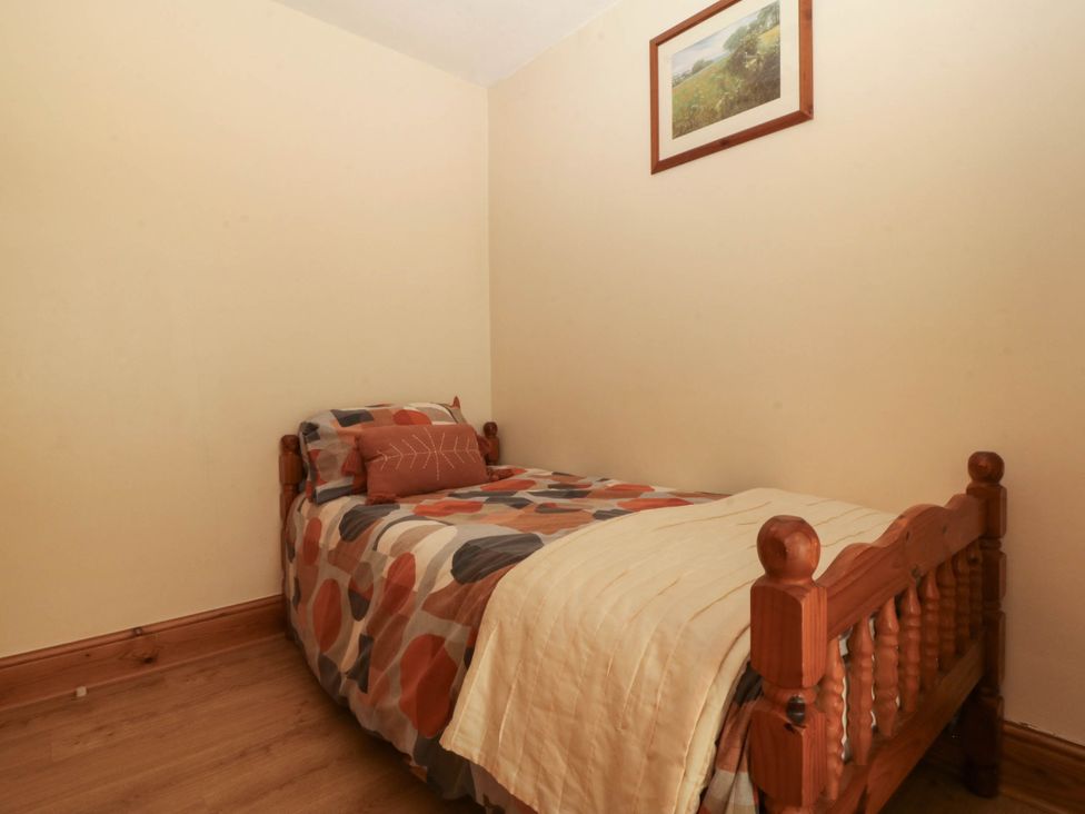 A bedroom with a single bed and a painting at Tyddyn in Dyffryn Ardudwy