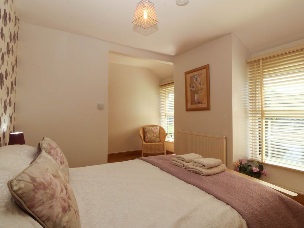 A bedroom with a bed and chair at Tyddyn in Dyffryn Ardudwy