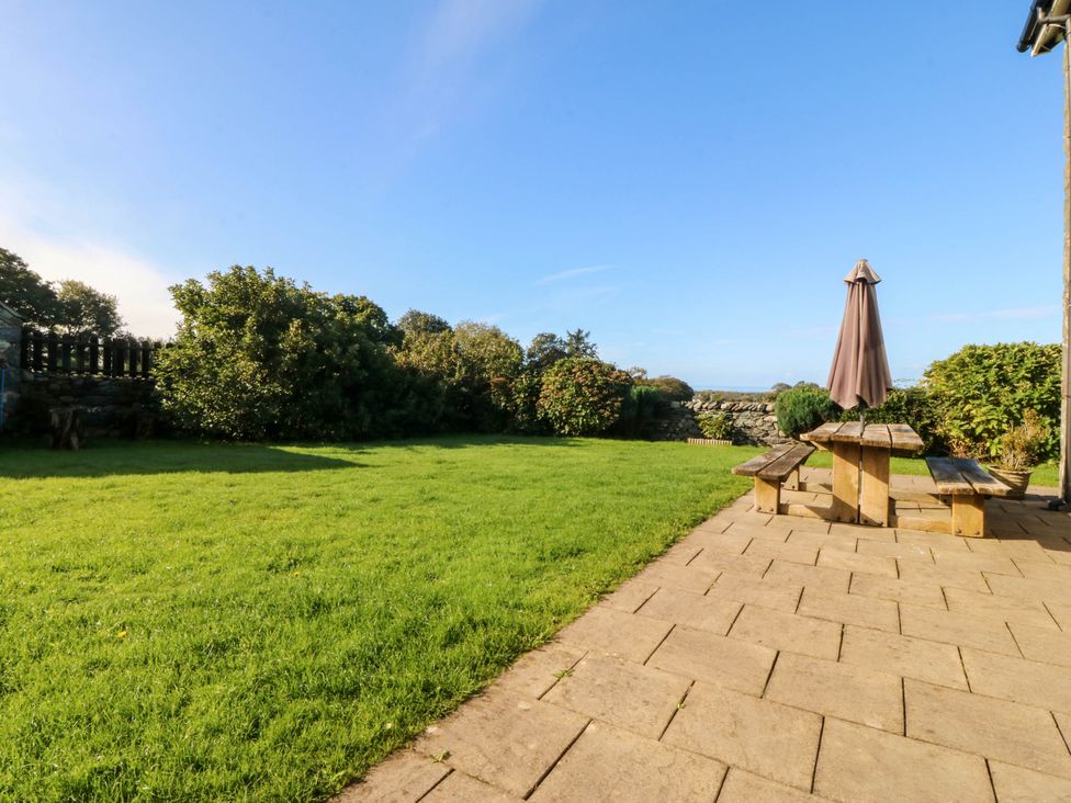 A garden with a table and parasol at Tyddyn in Dyffryn Ardudwy