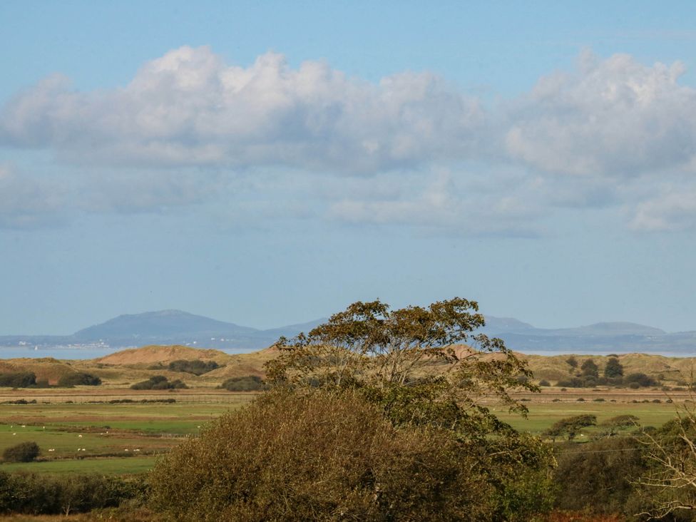A landscape with clouds, trees and mountains at Tyddyn in Dyffryn Ardudwy