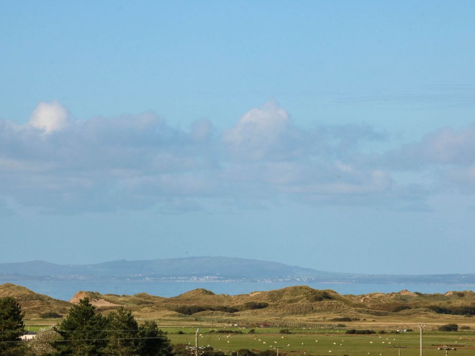 A landscape view of hills and ocean with sheep at Tyddyn in Dyffryn Ardudwy