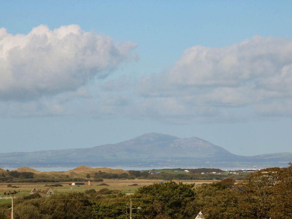 View of mountains and fields under a cloudy sky at Tyddyn in Dyffryn Ardudwy
