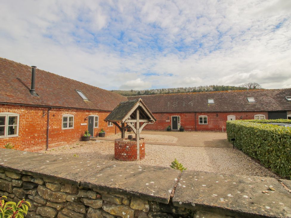 An outdoor area with a well and gravel path at The Wain House in Westhope near Church Stretton