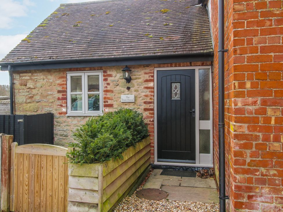 An entrance with a black door and stone walls at The Wain House Westhope near Church Stretton