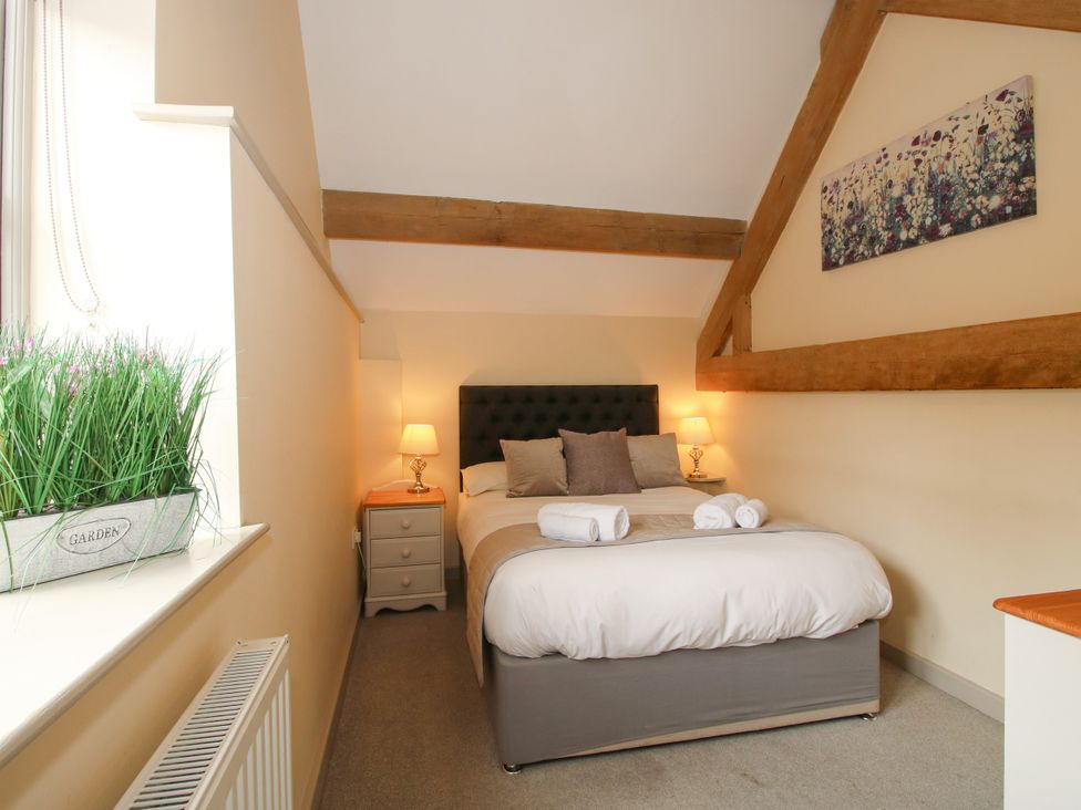 A bedroom with a bed and nightstand at The Wain House in Westhope near Church Stretton