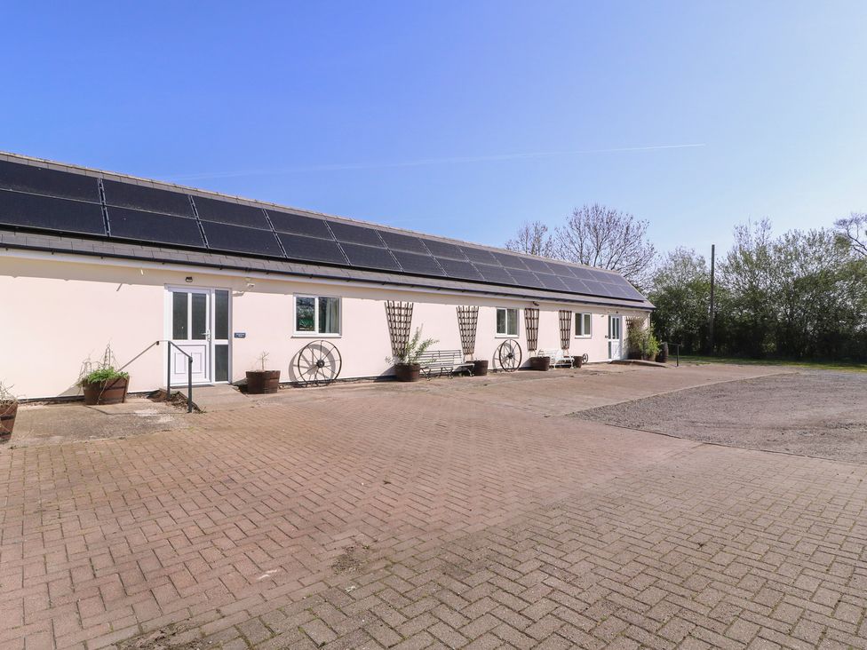 An outdoor area with a building featuring solar panels at The Turbles - Swallows Nest Castlemorton near Welland