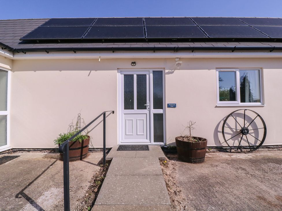 An exterior view of a house entrance with solar panels at The Turbles - Swallows Nest in Castlemorton near Welland