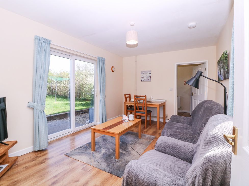 A living room with a sofa and dining area at The Turbles - Swallows Nest in Castlemorton near Welland