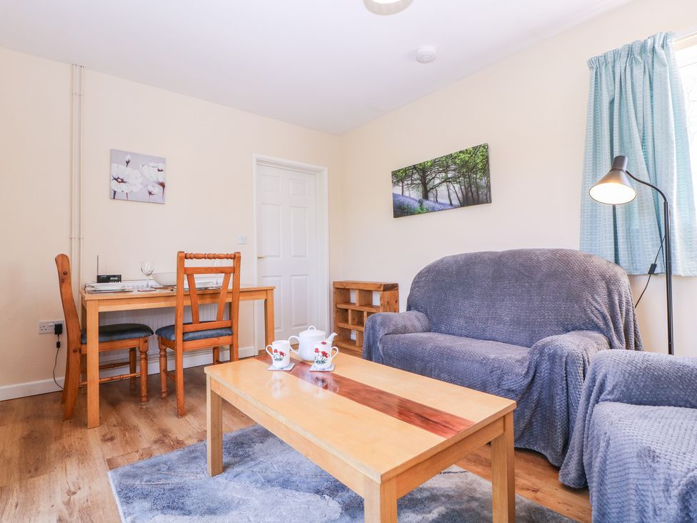 A living room with a sofa and dining table at The Turbles - Swallows Nest Castlemorton near Welland