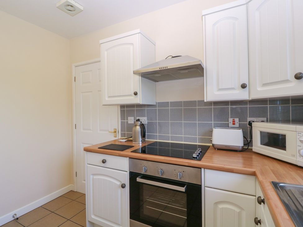 A kitchen with appliances and cabinets at The Turbles - Swallows Nest Castlemorton near Welland