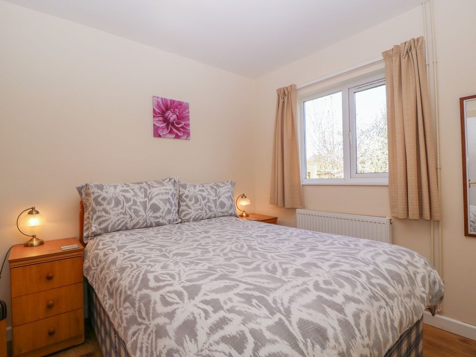 A bedroom with a bed and bedside table at The Turbles - Swallows Nest Castlemorton near Welland