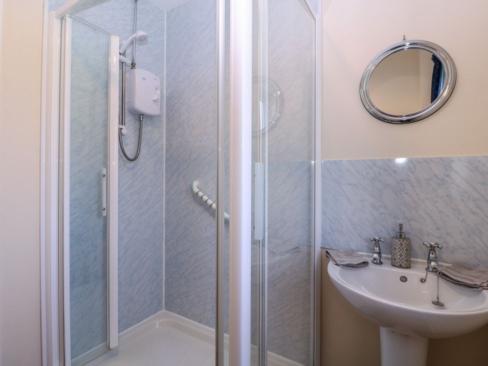 A shower with a sink and mirror at The Turbles - Swallows Nest in Castlemorton near Welland