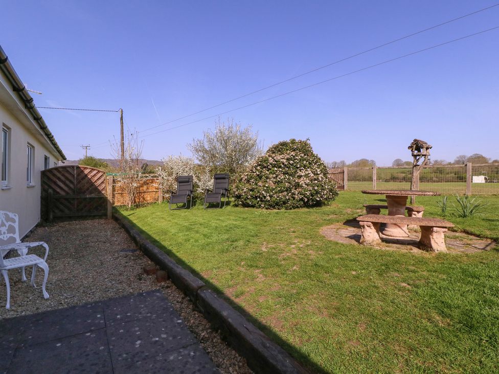 A garden with chairs and a table at The Turbles - Swallows Nest Castlemorton near Welland