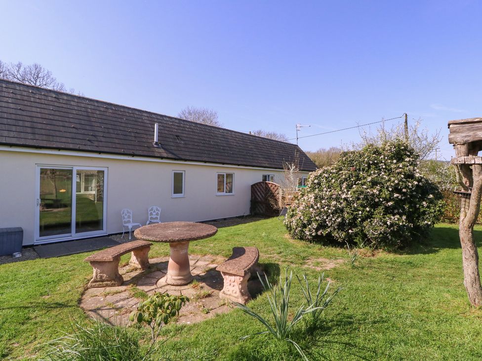 A garden with a stone table and chairs at The Turbles - Swallows Nest Castlemorton near Welland