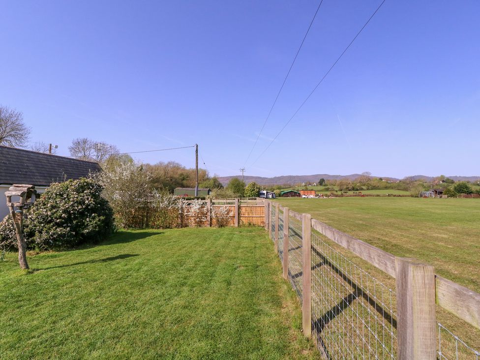 A view of a field with a fence and trees at The Turbles - Swallows Nest Castlemorton near Welland