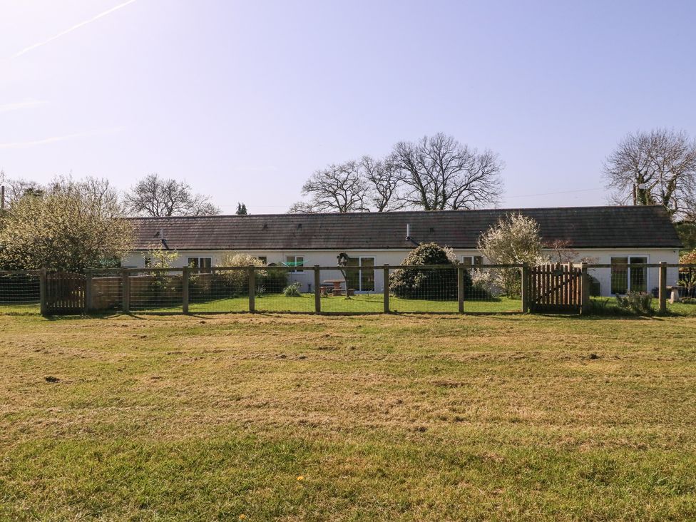 A building with a fence and grass at The Turbles - Swallows Nest Castlemorton near Welland