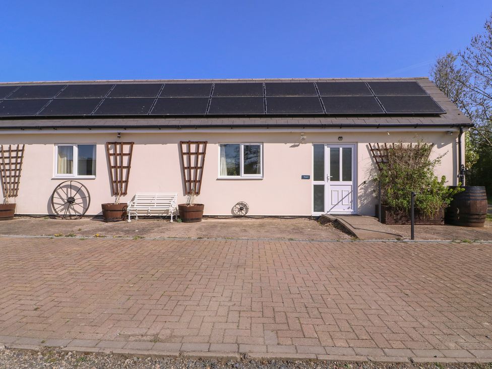 An outdoor view of a building with solar panels at The Turbles - Wagtail in Castlemorton near Welland