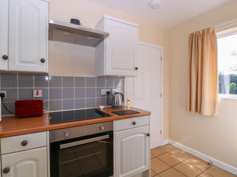 A kitchen with cabinets and an electric cooker at The Turbles - Wagtail in Castlemorton near Welland
