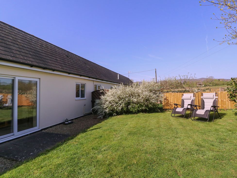 A garden area with chairs near a house at The Turbles - Wagtail Castlemorton near Welland