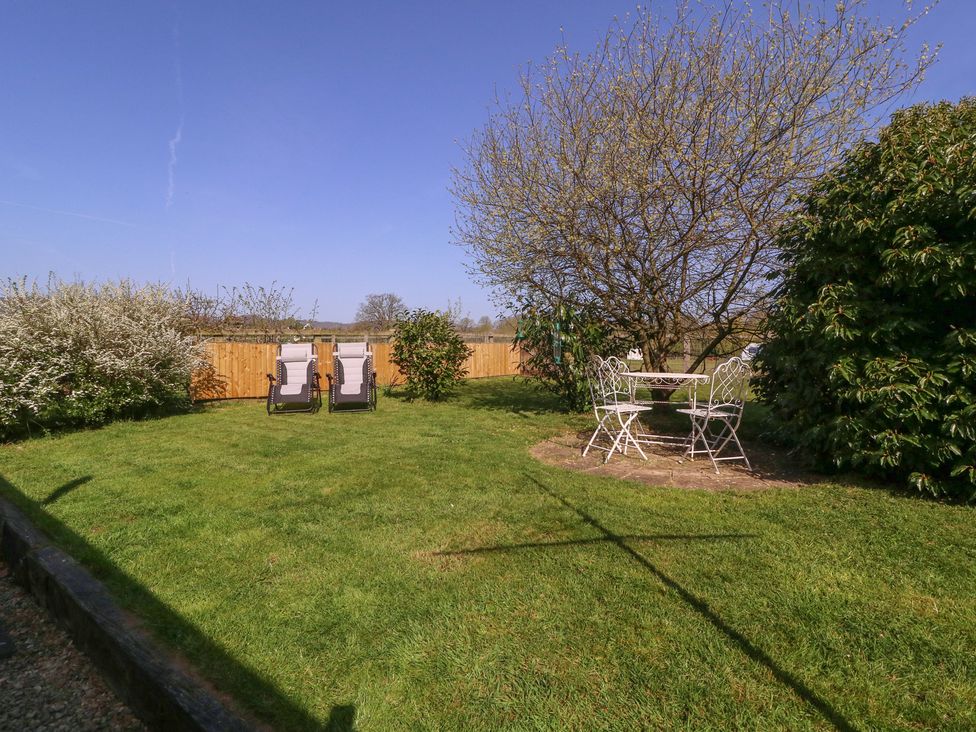 A garden with a table and chairs at The Turbles - Wagtail Castlemorton near Welland