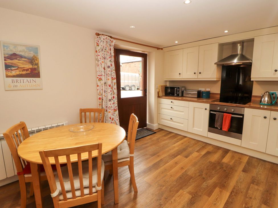 A kitchen with a dining table and appliances at The Old Bothy Bolton Low Houses near Wigton