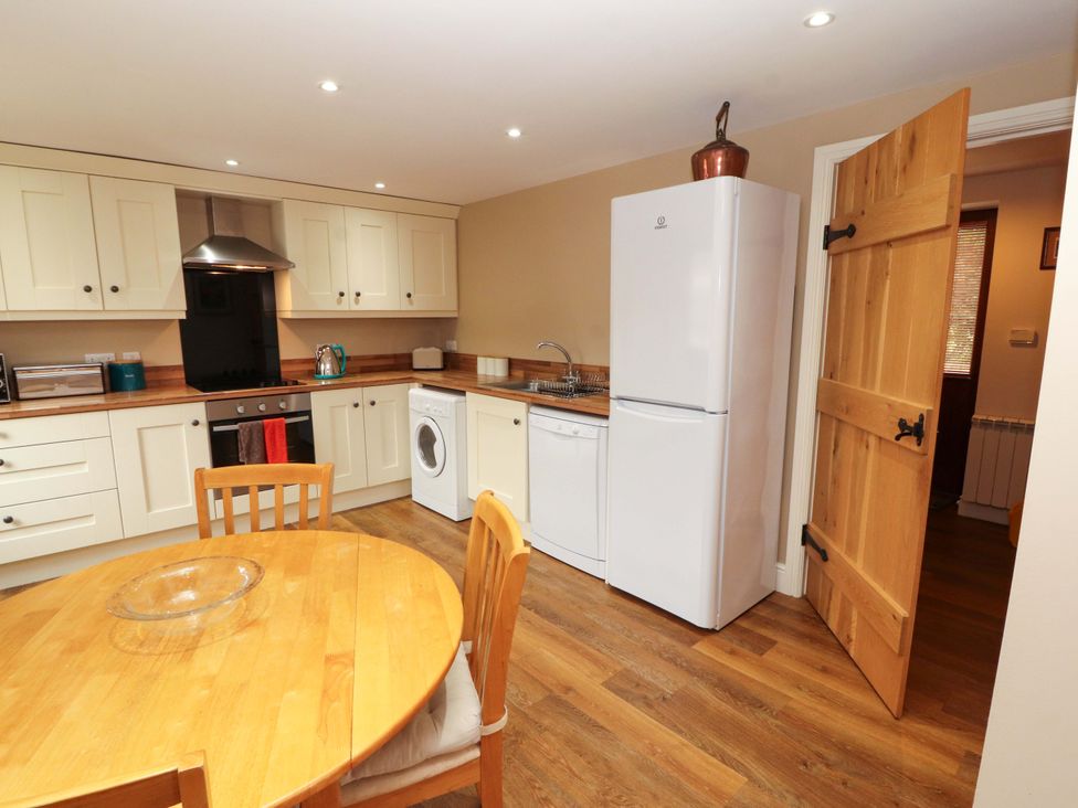 A kitchen with wooden table and appliances at The Old Bothy Bolton Low Houses near Wigton