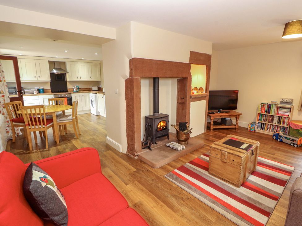 A living room with a sofa, dining table and television at The Old Bothy Bolton Low Houses near Wigton