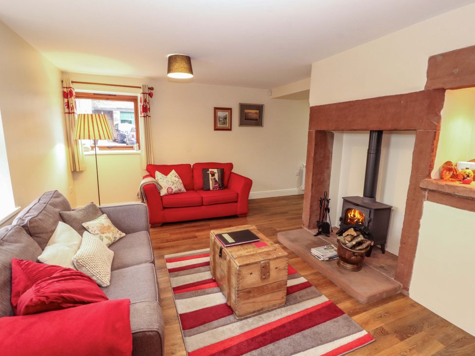 A living room with a fireplace and seating area at The Old Bothy Bolton Low Houses near Wigton