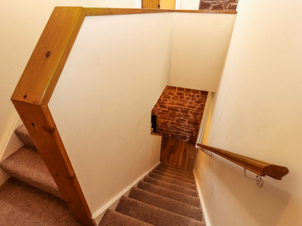 A staircase with wooden handrail and wall at The Old Bothy Bolton Low Houses near Wigton