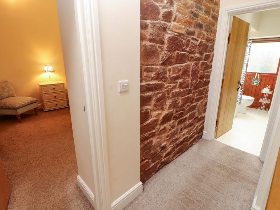 A hallway with a view to a bedroom and bathroom at The Old Bothy Bolton Low Houses near Wigton