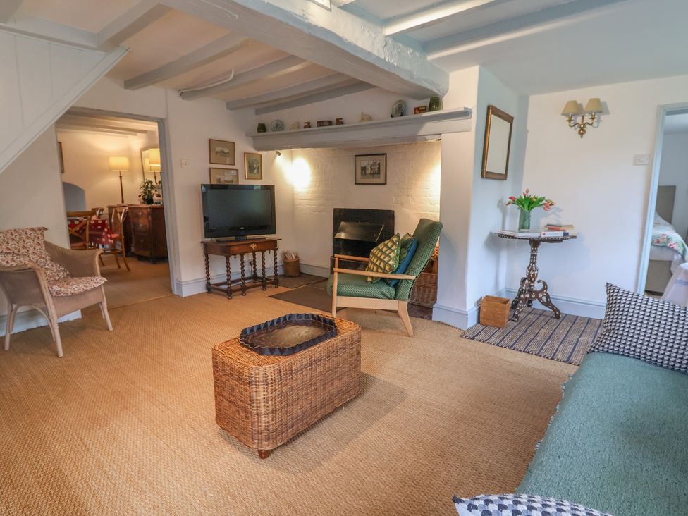A living room with a television and fireplace at Wolvesacre Mill Cottage Agden near Whitchurch