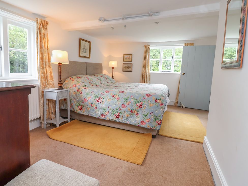 A bedroom with a bed and lamp at Wolvesacre Mill Cottage Agden near Whitchurch