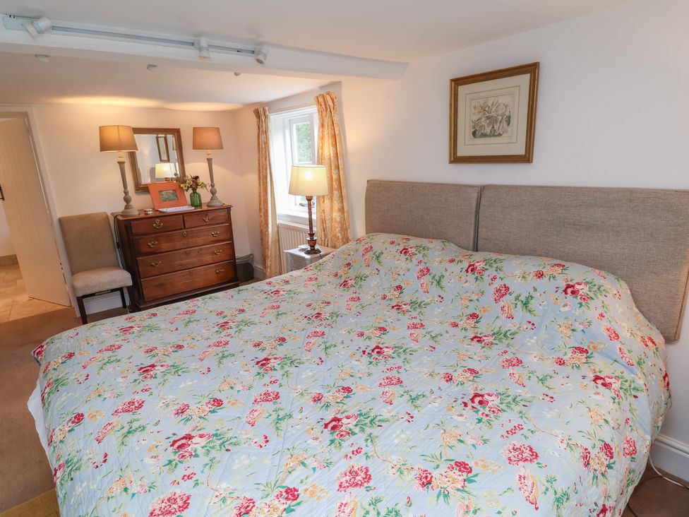 A bedroom with a bed and dresser at Wolvesacre Mill Cottage in Agden near Whitchurch