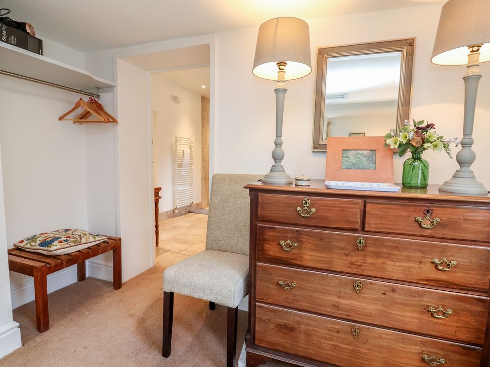 A bedroom with a dresser and chair at Wolvesacre Mill Cottage Agden near Whitchurch