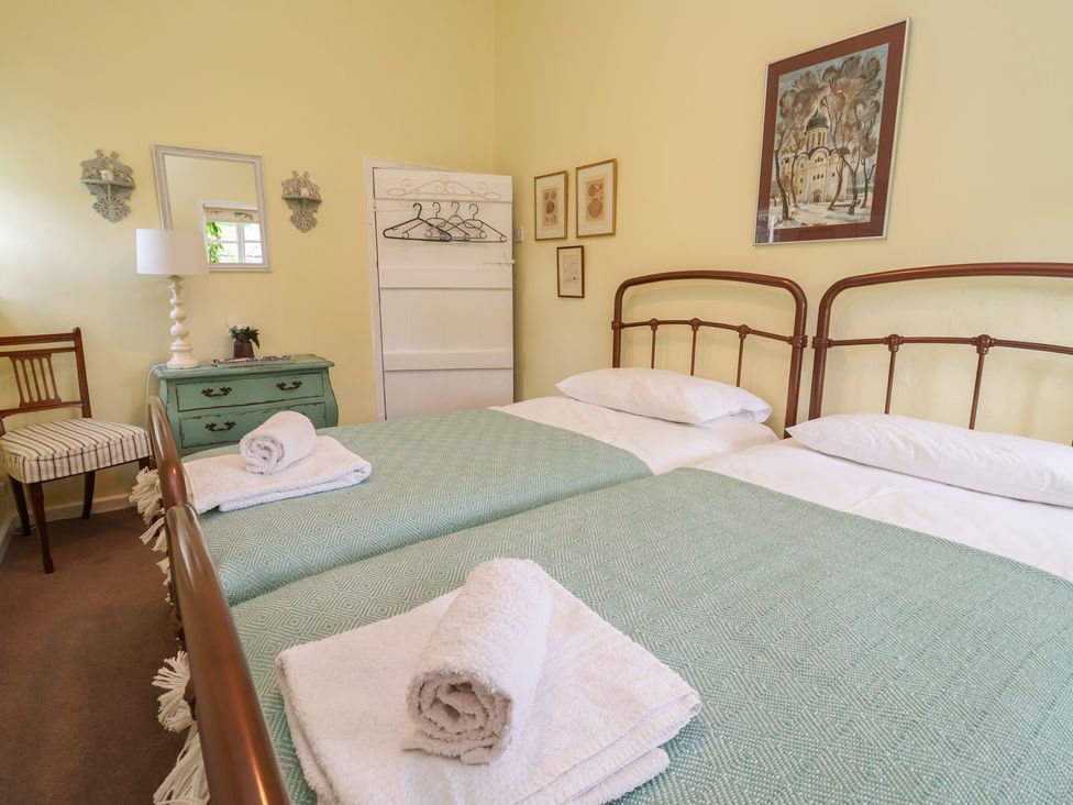 A bedroom with two beds and a dresser at Wolvesacre Mill Cottage in Agden near Whitchurch