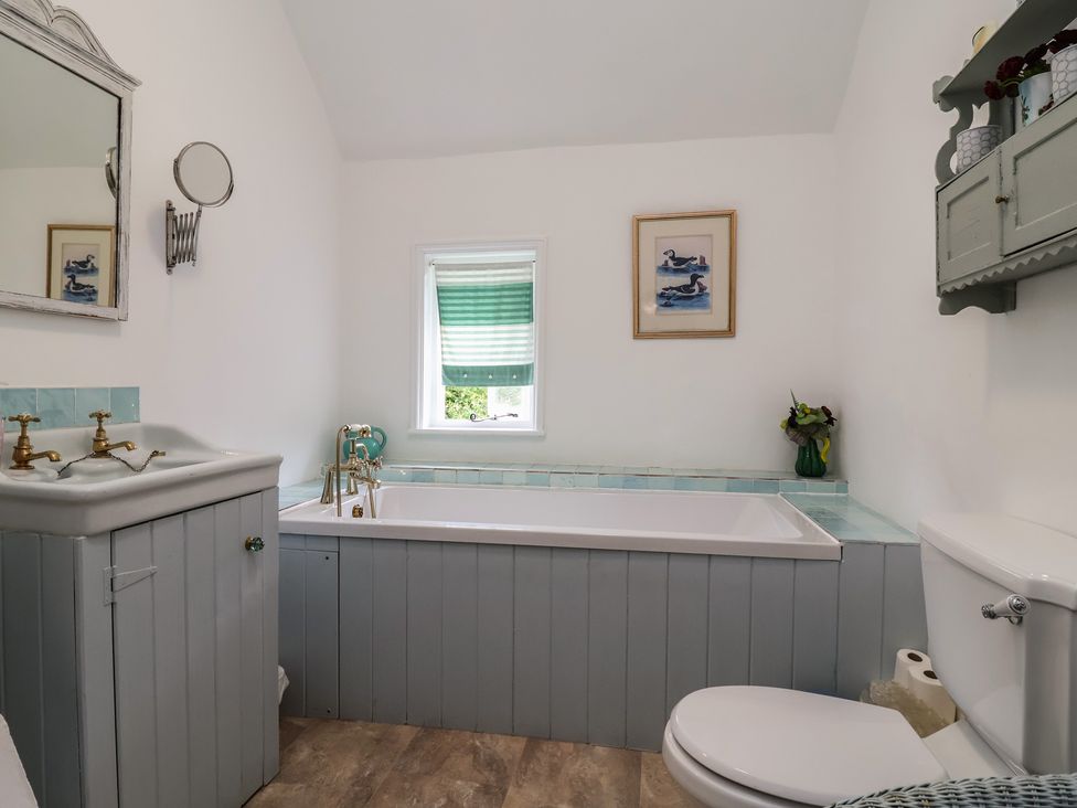 A bathroom with a bathtub and sink at Wolvesacre Mill Cottage in Agden near Whitchurch