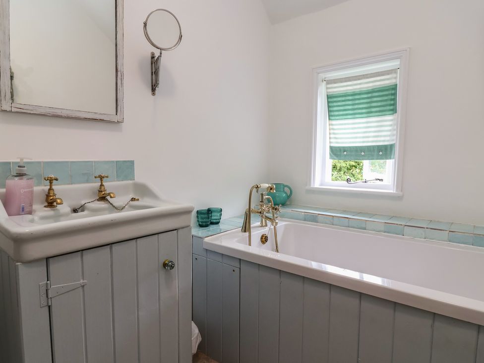A bathroom with a sink and bathtub at Wolvesacre Mill Cottage Agden near Whitchurch