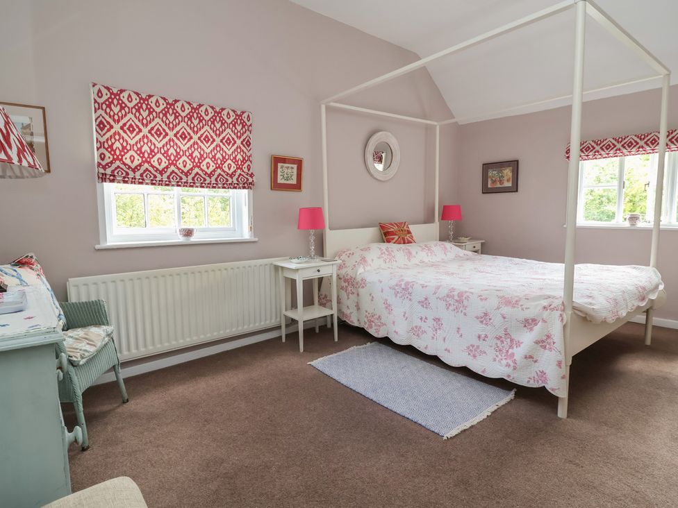 A bedroom with a bed and bedside tables at Wolvesacre Mill Cottage in Agden near Whitchurch
