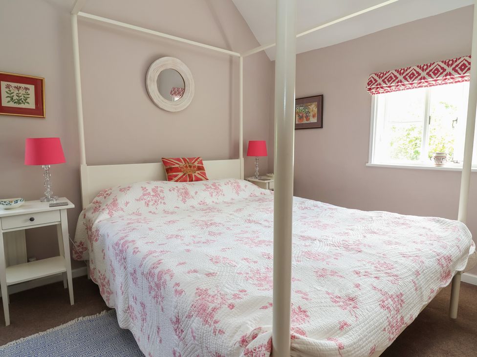 A bedroom with a four-poster bed and a nightstand at Wolvesacre Mill Cottage Agden near Whitchurch