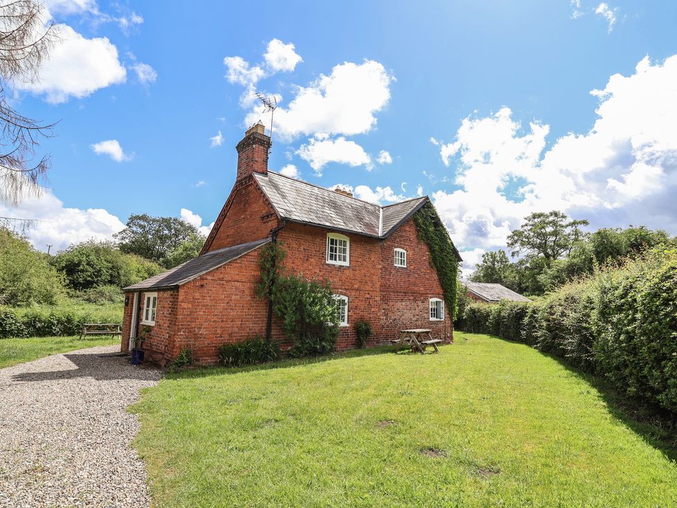 A house with a garden and pathway at Wolvesacre Mill Cottage Agden near Whitchurch