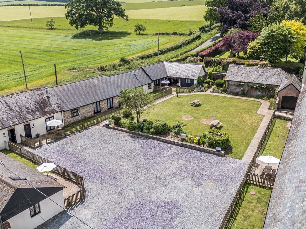 An outdoor area with buildings and a garden at The Old Stables in Winterborne Stickland