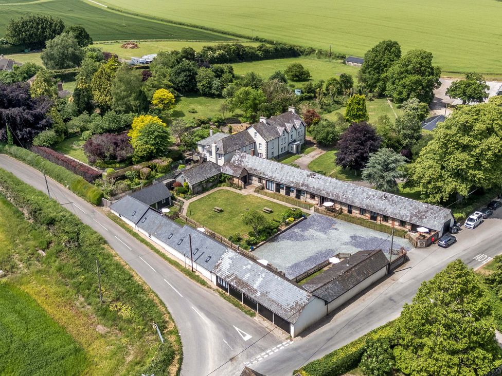 An aerial view of a countryside property with gardens and buildings at The Old Stables in Winterborne Stickland