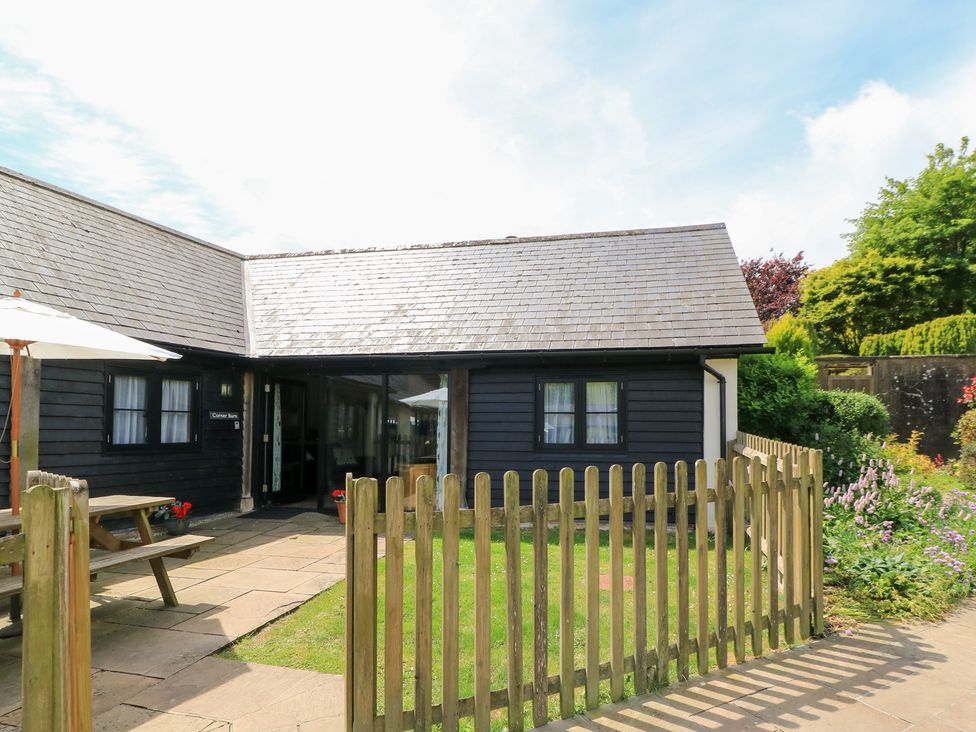 An outdoor area with a table and umbrella at Corner Barn in Winterborne Stickland