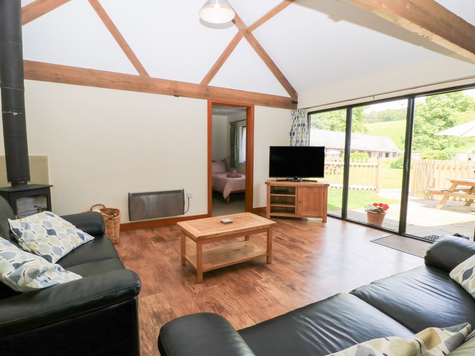 A living room with a sofa and coffee table at Corner Barn in Winterborne Stickland