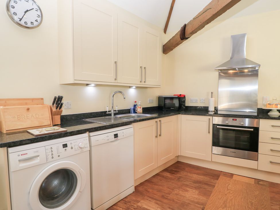 A kitchen with various appliances and cabinets at Corner Barn Winterborne Stickland